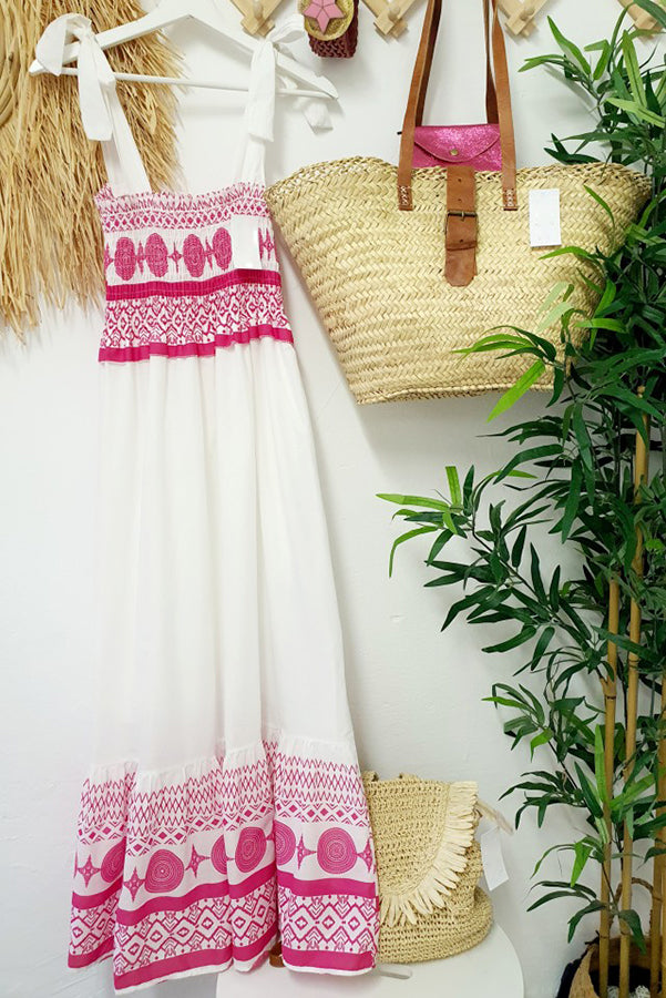 Lifestyle shot of a woman enjoying a sunny day, elegantly styled in the white Talia boho maxi dress.