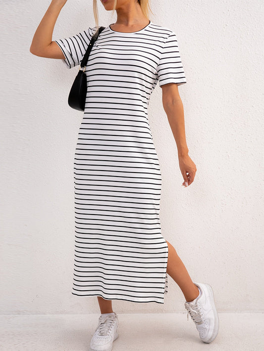 Front view of model wearing a white and blue striped jersey midi dress, standing casually outdoors.