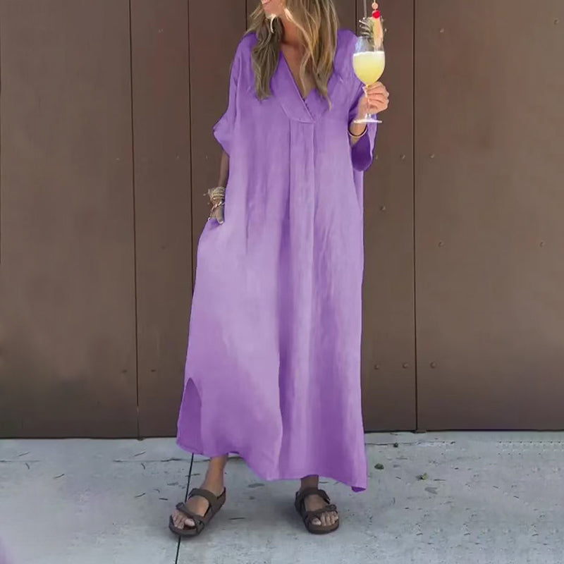 Full-body shot of a woman in a grey Aurora casual V-neck dress, walking gracefully in an urban setting.