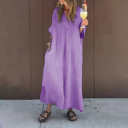 Full-body shot of a woman in a grey Aurora casual V-neck dress, walking gracefully in an urban setting.