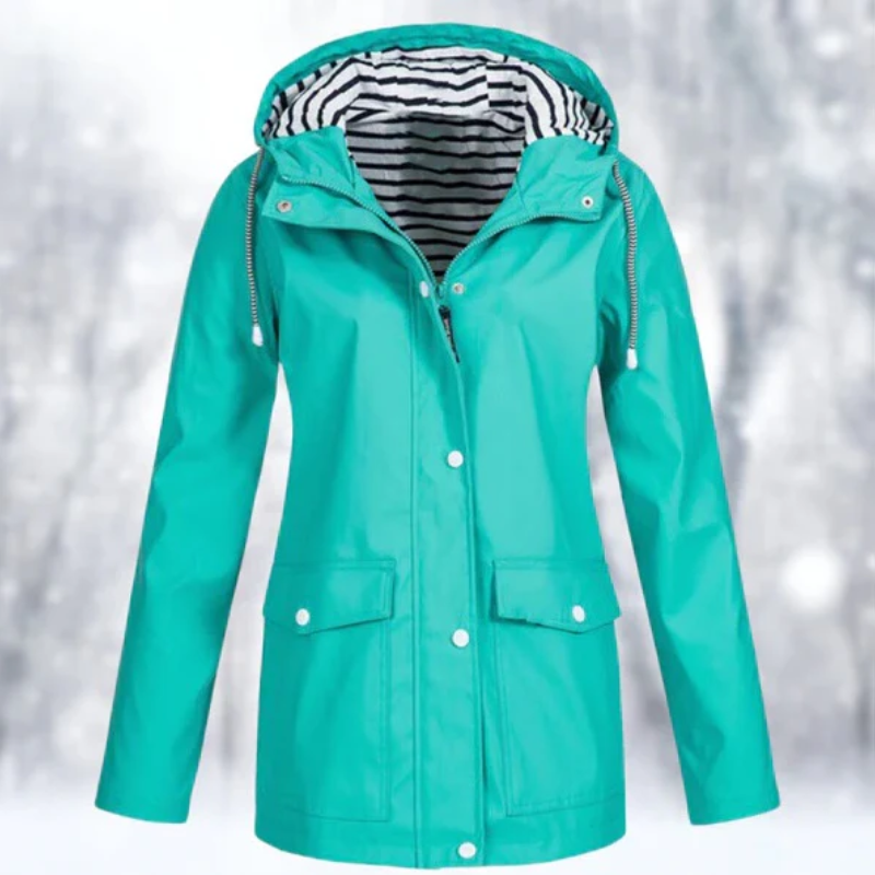 Side profile of a woman wearing a blue Lyra waterproof rain jacket, highlighting the comfortable fit and functional pockets.