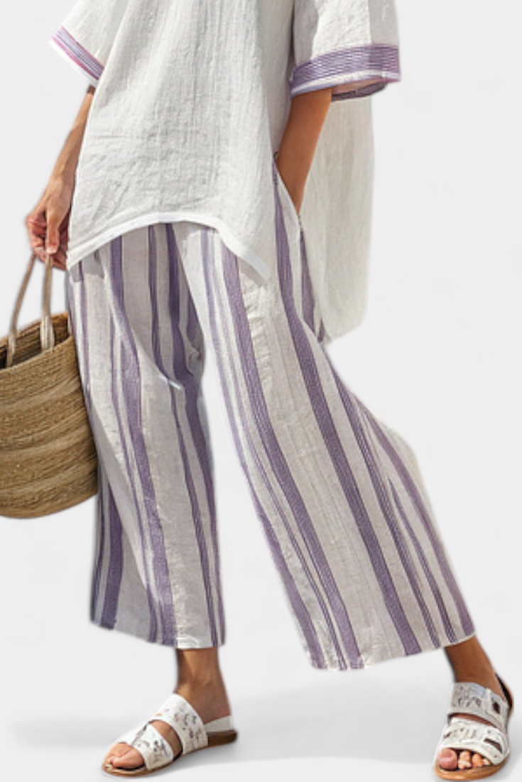 Side profile of a woman lounging comfortably in the purple striped two-piece summer set, highlighting the flowy fit.