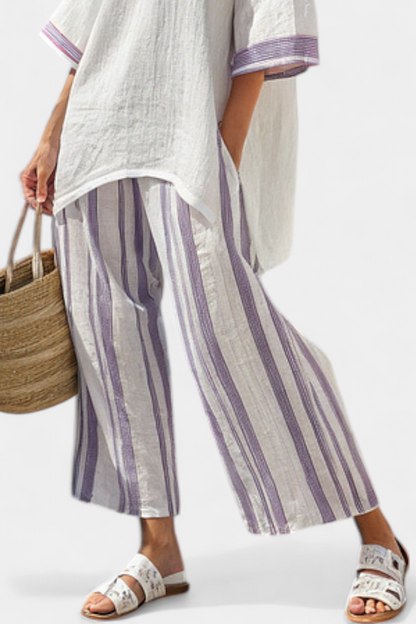 Side profile of a woman lounging comfortably in the purple striped two-piece summer set, highlighting the flowy fit.