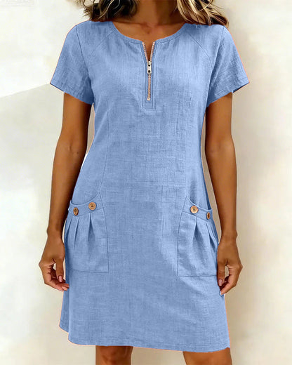 Front view of a woman wearing a blue Clara short dress, styled casually for a daytime look.
