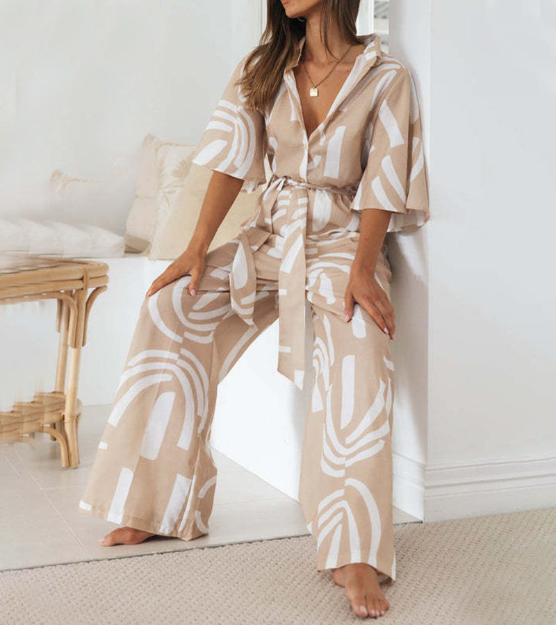 Lifestyle image of a woman enjoying a sunny day, perfectly styled in her elegant abstract jumpsuit.