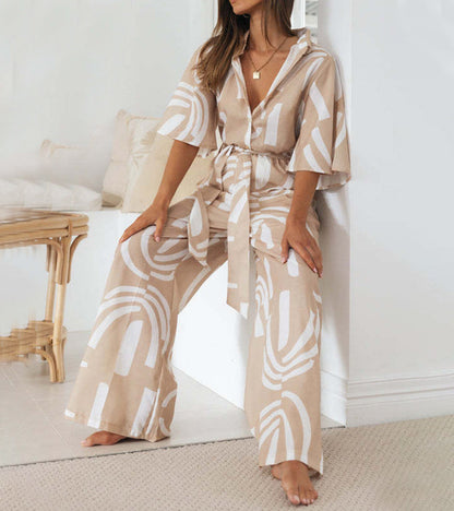 Lifestyle image of a woman enjoying a sunny day, perfectly styled in her elegant abstract jumpsuit.