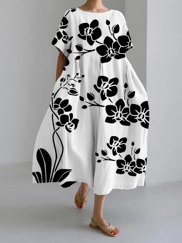 Front view of the Seraphina floral summer midi dress in white with black flower patterns, showcasing its relaxed floating style.