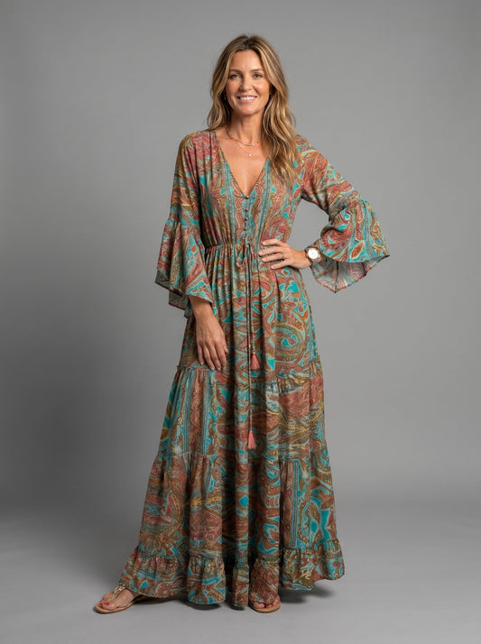 Front view of a woman wearing the blue floral maxi dress with a relaxed fit, hands in pockets.