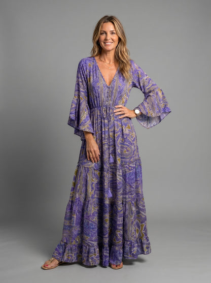 Woman spinning in the blue floral maxi dress, emphasizing the flowing movement of the skirt.