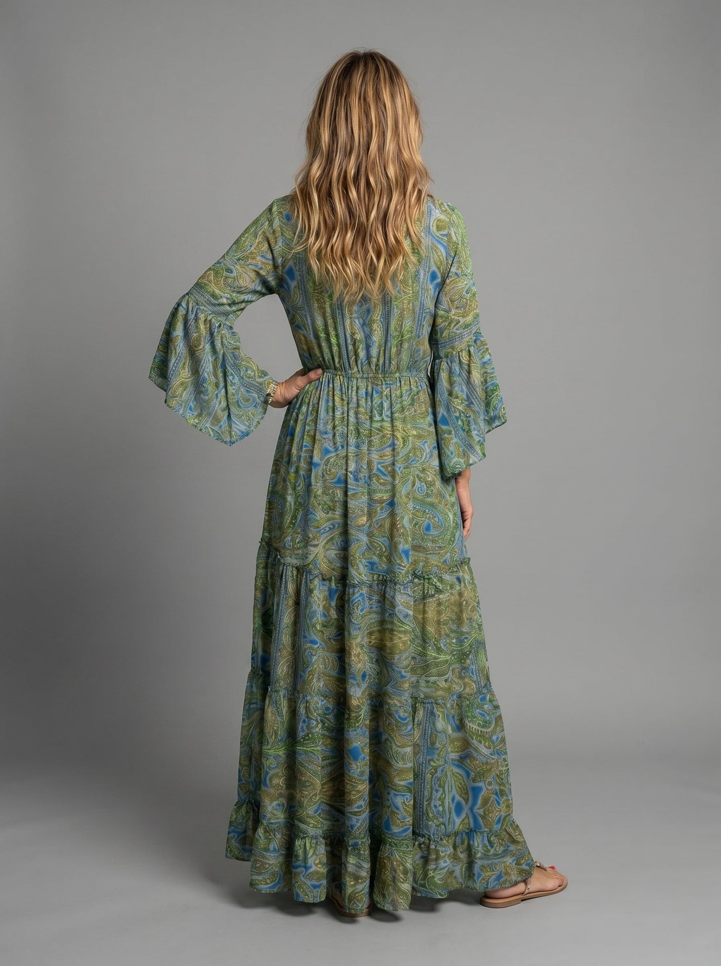 Lifestyle image of the blue floral maxi dress worn at a beach setting, ideal for vacations.