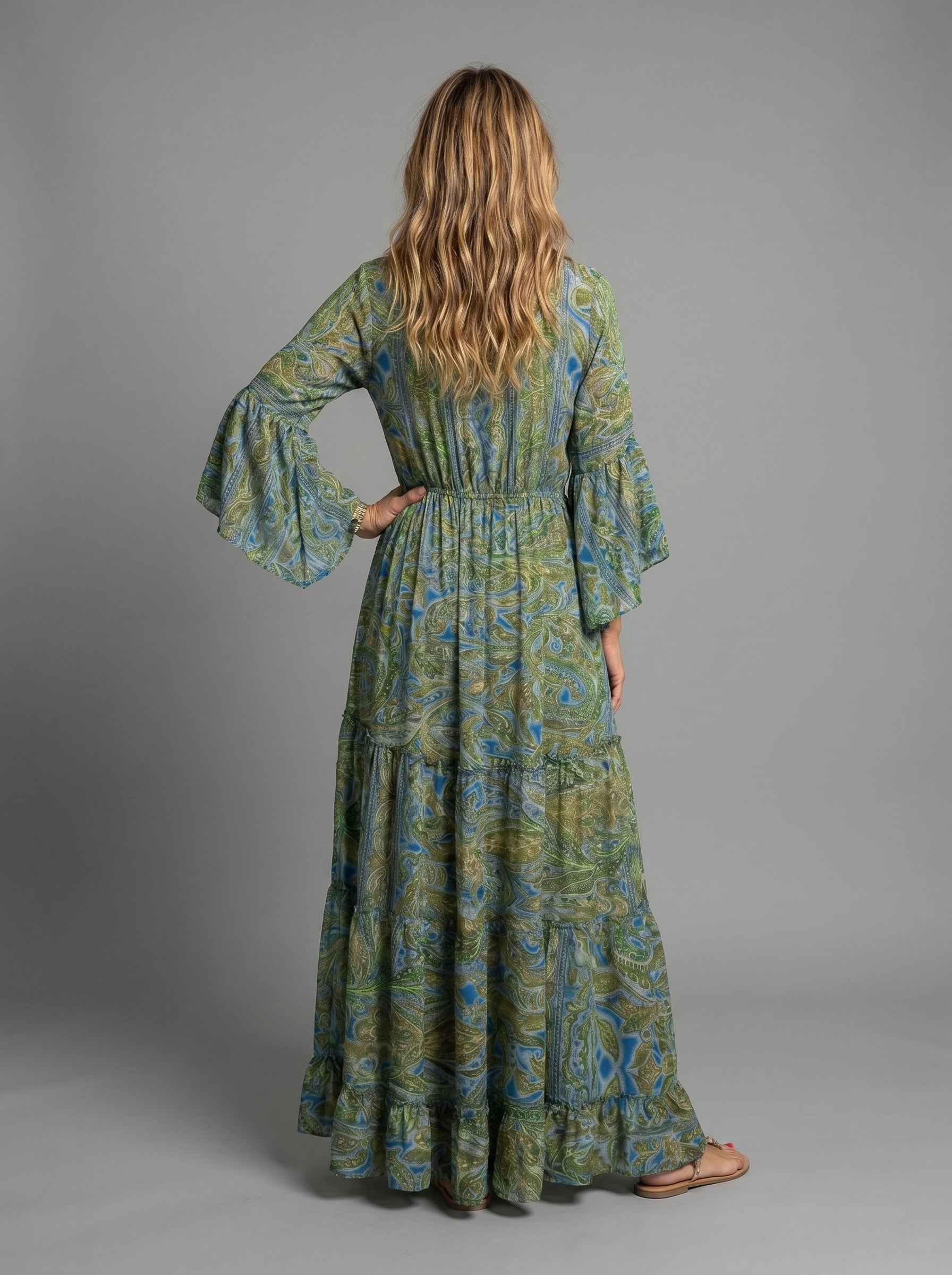 Lifestyle image of the blue floral maxi dress worn at a beach setting, ideal for vacations.