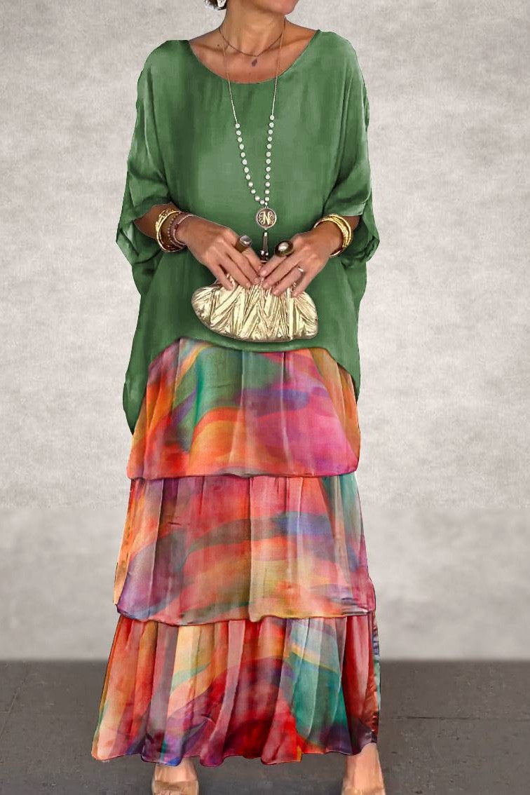 A full-length front view of the Seraphina flowy layered maxi dress in a vibrant green-orange color, showcasing its elegant draping and relaxed fit on a model.