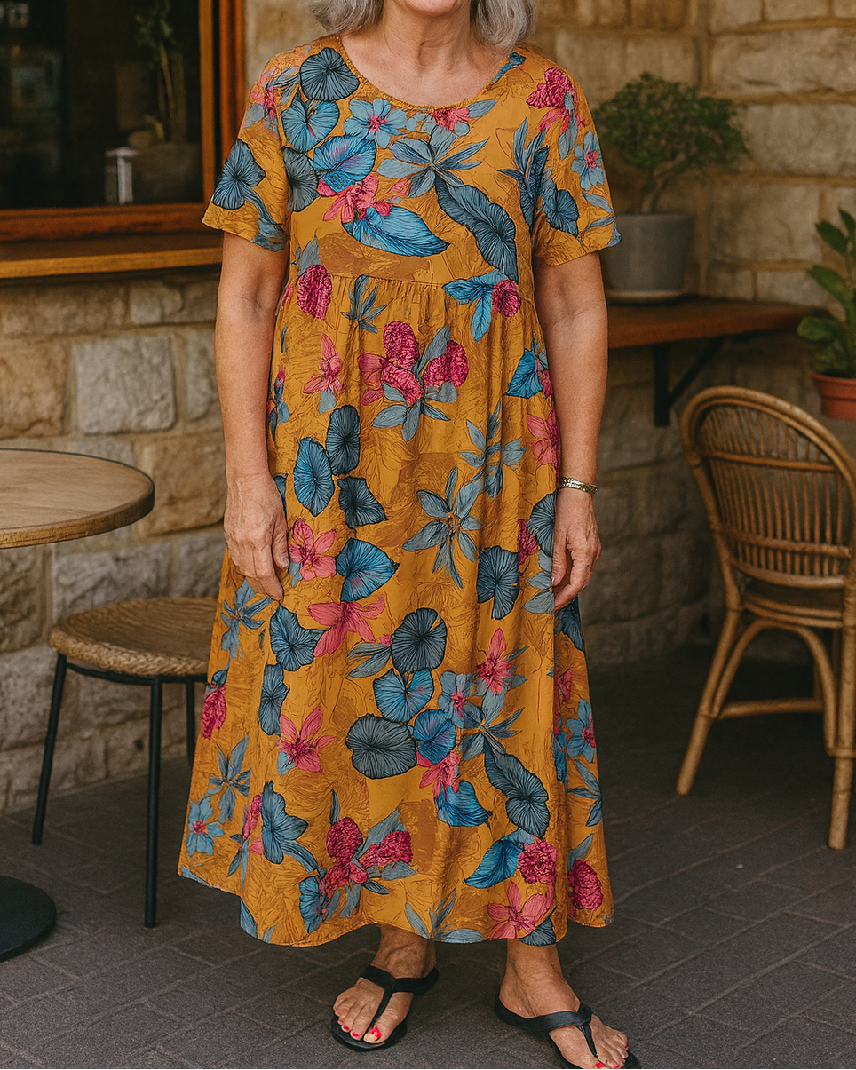 Woman wearing the Eliza floral maxi dress in a garden, enjoying the sun and showing its flowy movement.