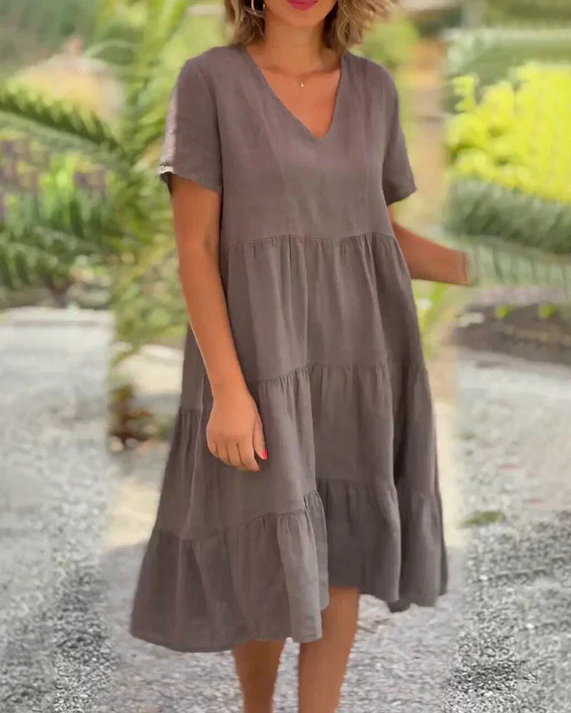 Back view of the Esmée flowy boho midi dress in blue, showing the elegant drape and flow of the tiered skirt.