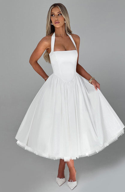 Front view of a woman posing in a white Evanthe halter neck midi dress with a full tulle skirt.