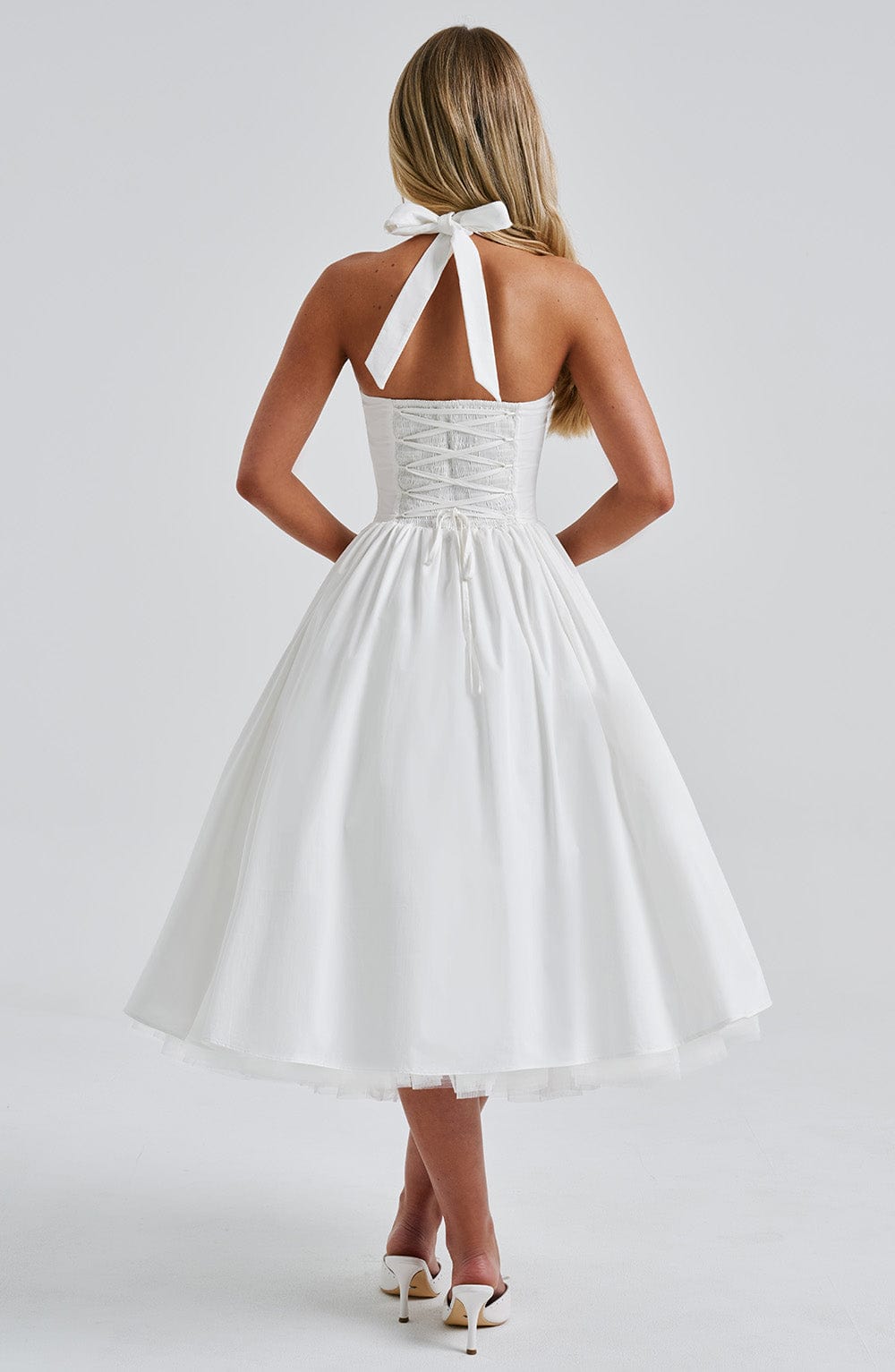 Side profile of the elegant white midi dress, showcasing the structured bodice and voluminous tulle skirt.