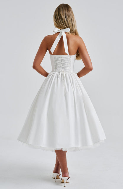 Side profile of the elegant white midi dress, showcasing the structured bodice and voluminous tulle skirt.