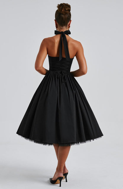 A woman twirling playfully in the white Evanthe midi dress, emphasizing the airy movement of the tulle skirt.