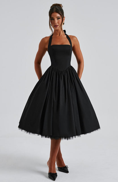 Detail shot of the crisp fabric texture and the delicate tulle layers of the elegant halter neck midi dress.