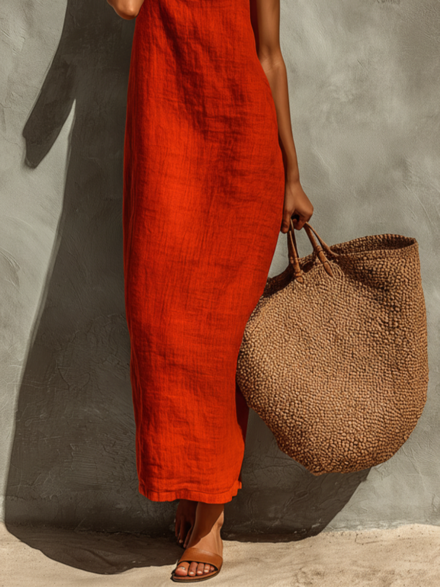 Woman posing playfully in the white Evie chic summer dress, accessorized for a sunny outdoor setting.