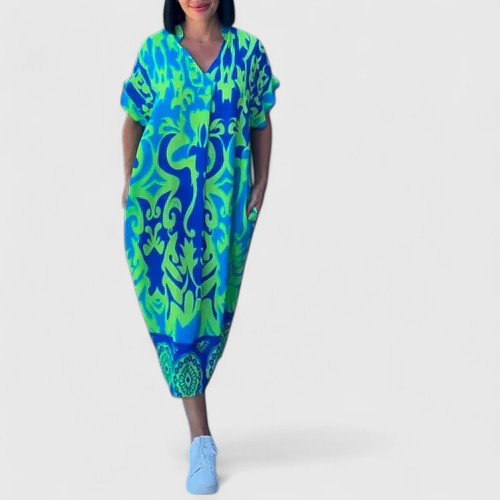 Side profile of a woman confidently posing in the blue blossoming floral midi dress, showcasing its flattering wrap fit.