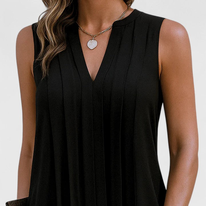 Close-up detail of the V-neckline on the black dress, emphasizing the refined stitching and quality of the material.