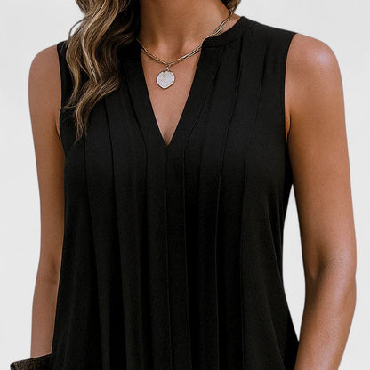 Close-up detail of the V-neckline on the black dress, emphasizing the refined stitching and quality of the material.