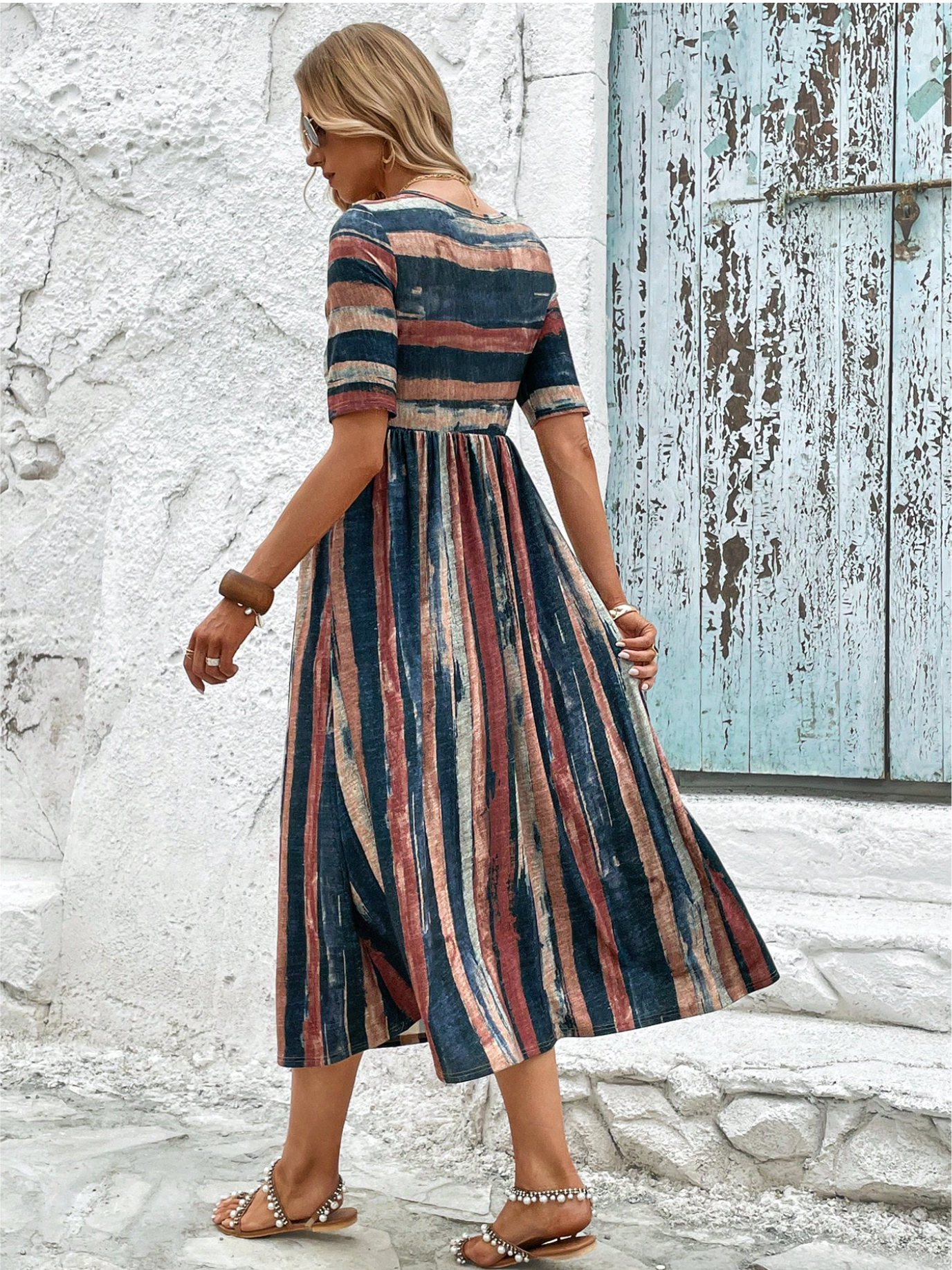 Side profile of a woman enjoying a sunny day, wearing the flowy Elara patterned midi summer dress with a casual yet chic vibe.