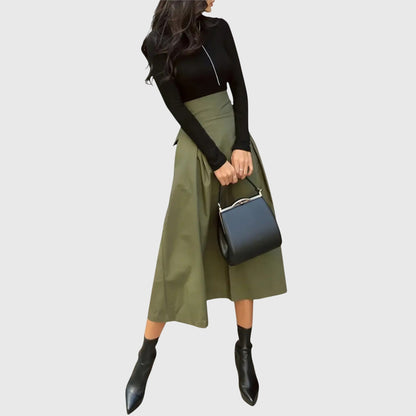 Front view of a woman wearing the green Jade flowy midi skirt, showcasing its elegant drape.