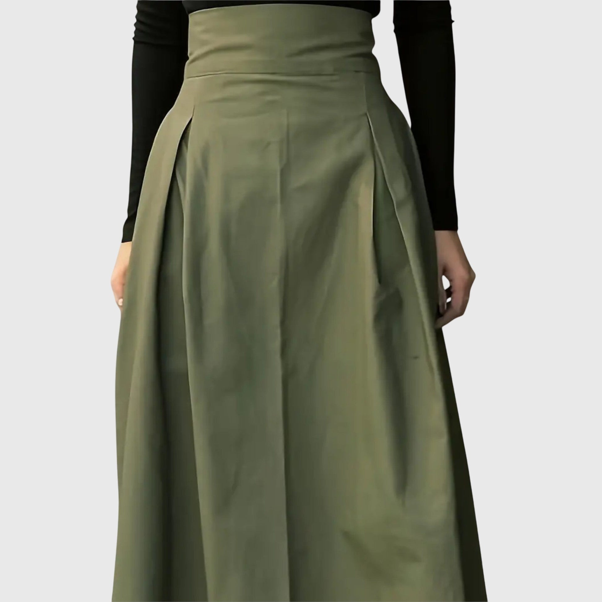 Side profile of a model walking, highlighting the movement and flared cut of the green flowy midi skirt.