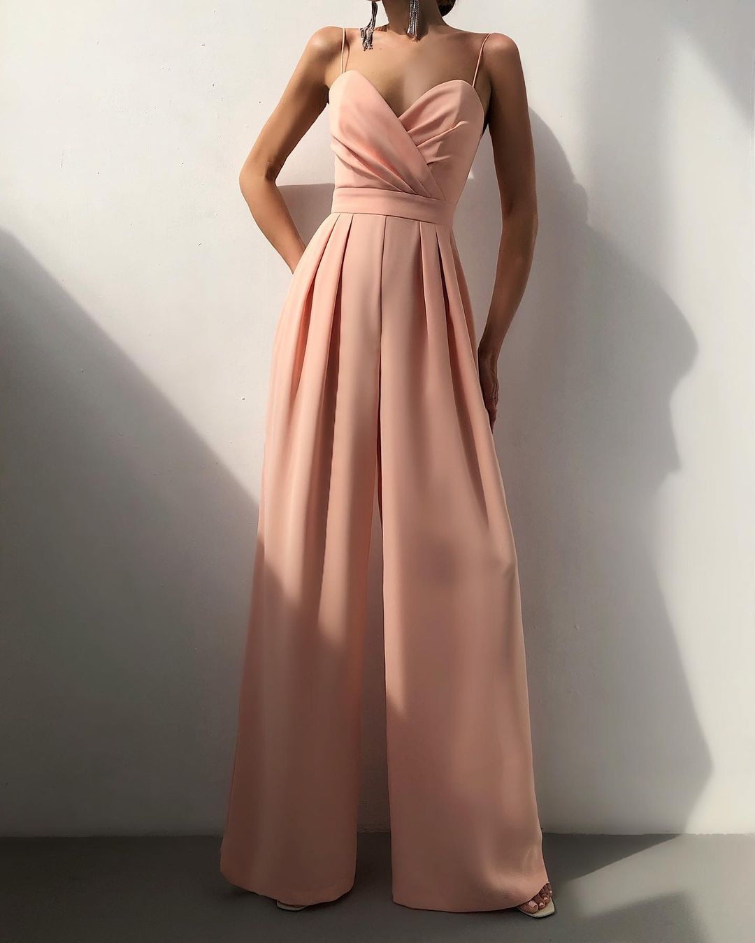 Back view of the Paloma jumpsuit in apricot, emphasizing the elegant drape of the fabric.