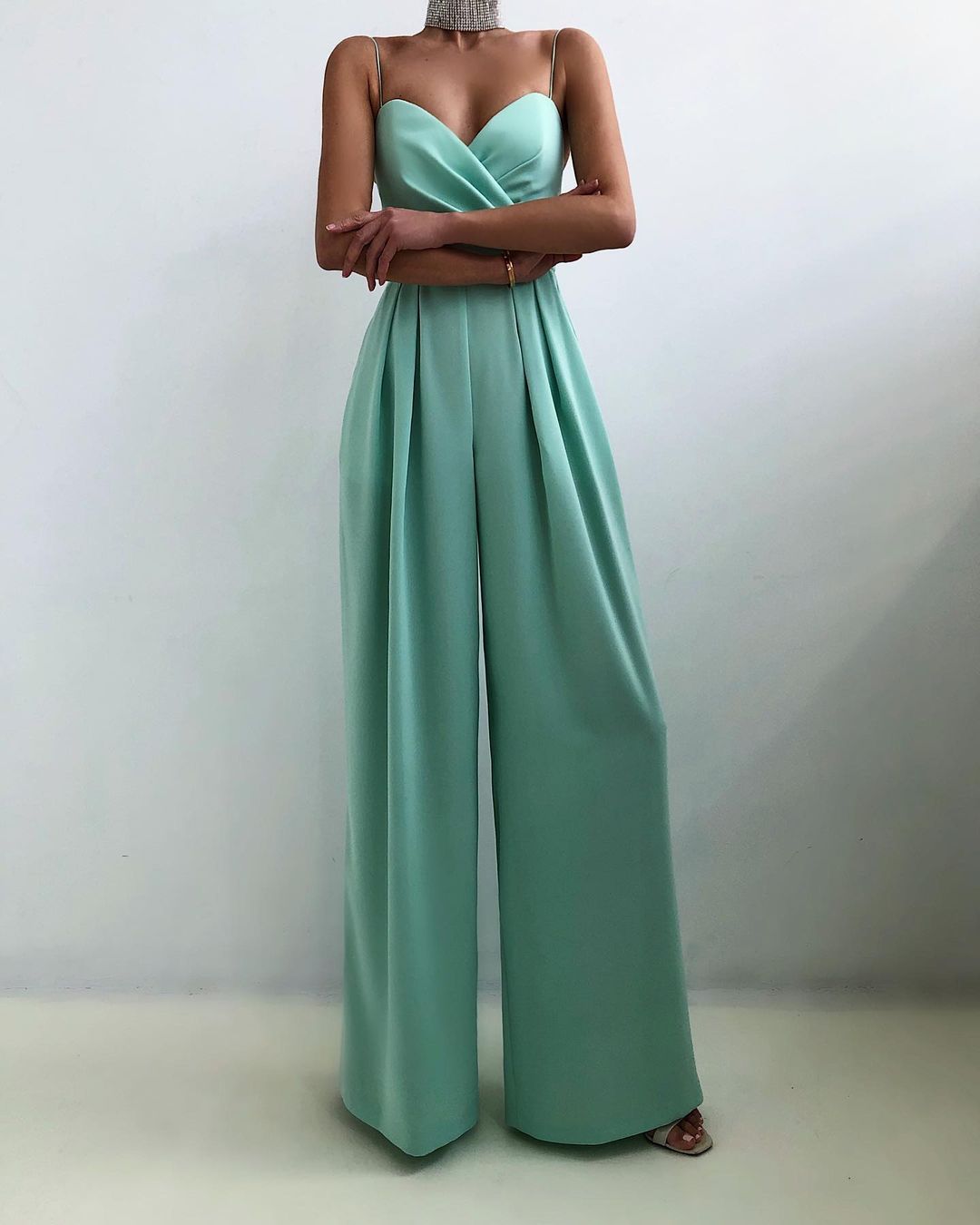 Lifestyle shot of a woman enjoying a cafe, wearing the yellow Paloma adjustable straps jumpsuit.