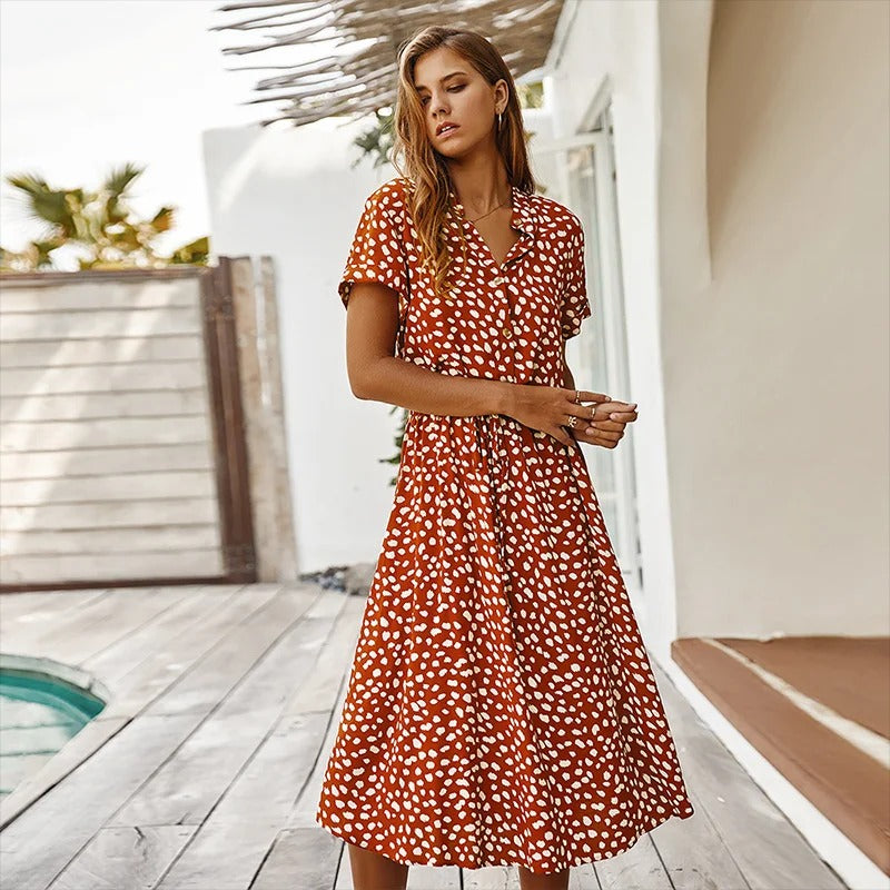 Close-up detail of the tie-waist and flowing skirt fabric of the printed midi dress, showcasing its texture.
