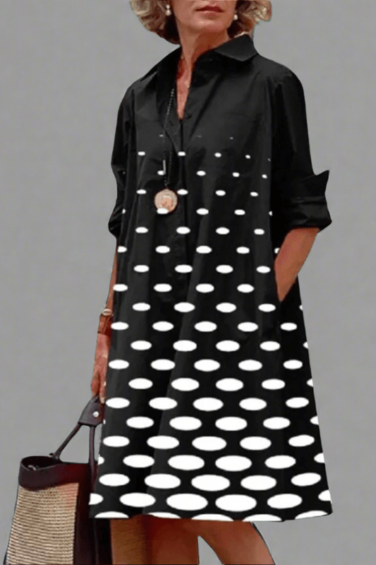 Front view of a woman wearing a black polka dot midi dress, showcasing its relaxed fit and elegant drape against a bright background.