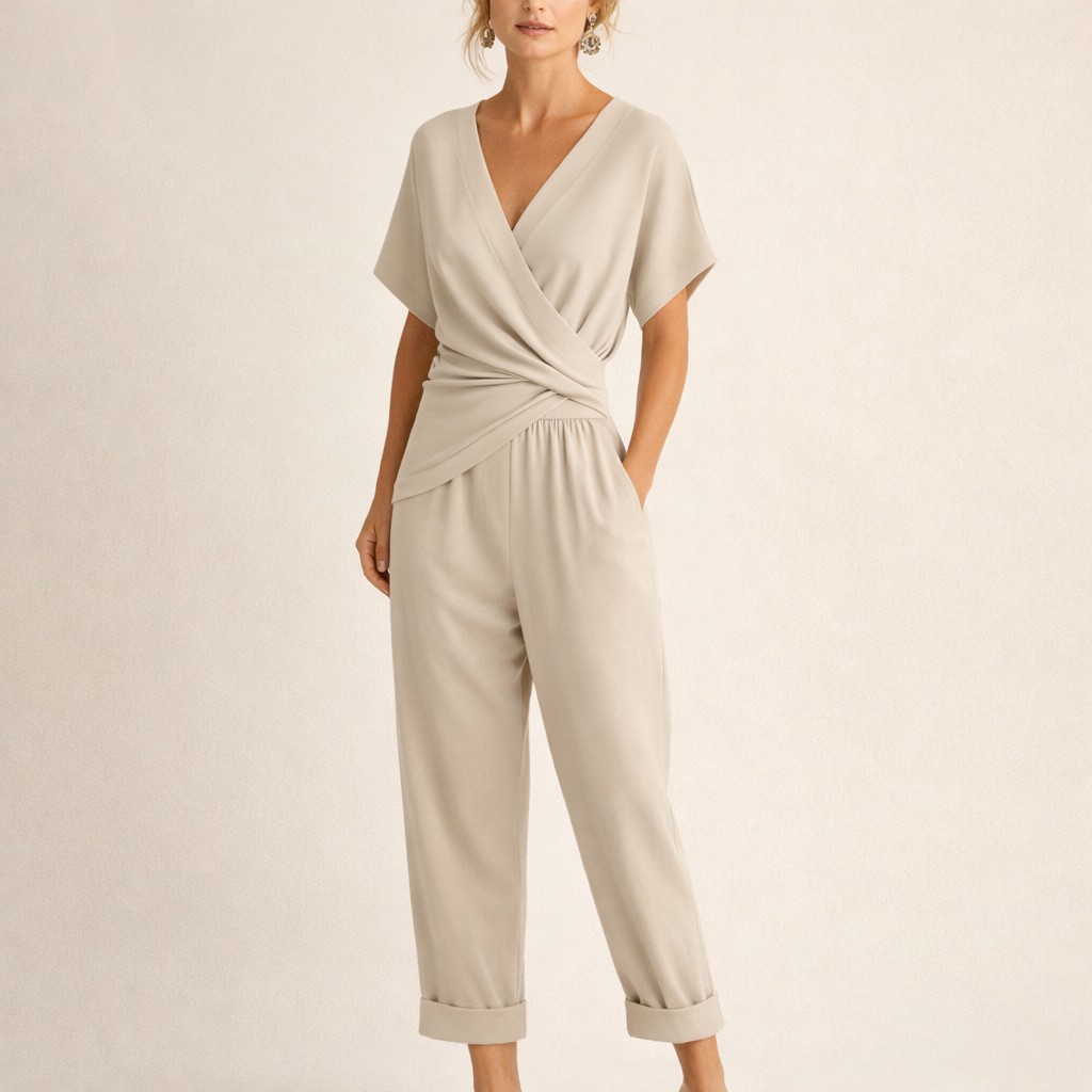 Front view of a woman wearing a beige chic wrap jumpsuit, showcasing the V-neckline and cropped legs.
