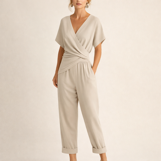 Front view of a woman wearing a beige chic wrap jumpsuit, showcasing the V-neckline and cropped legs.