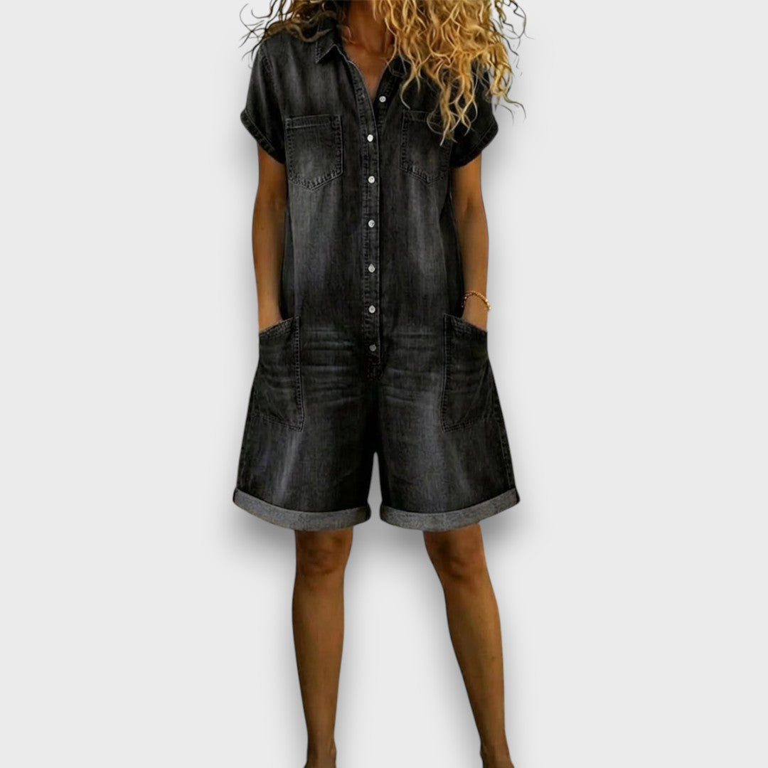 Side profile of a woman in a dark blue denim jumpsuit, showcasing the flattering drape and balanced silhouette.