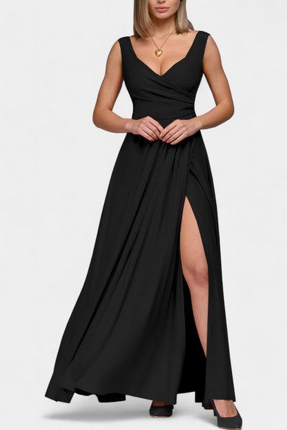 Model's hands gracefully holding the flowing skirt of the green Lila Draped Maxi Dress.