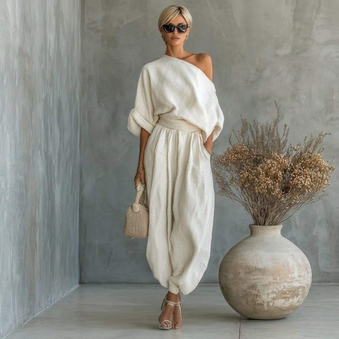 Front view of a woman wearing the white one-shoulder elegant two-piece set, styled casually.