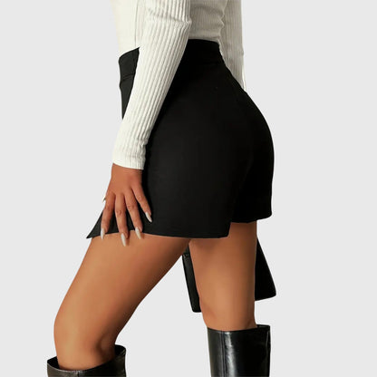 Lifestyle shot of a woman wearing the black Luna structured mini skirt, paired with a blouse, walking confidently outdoors.