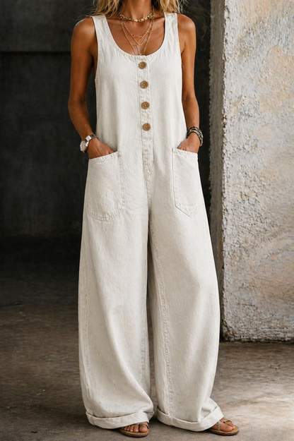 Front view of a woman wearing a light-colored casual summer jumpsuit, standing outdoors.