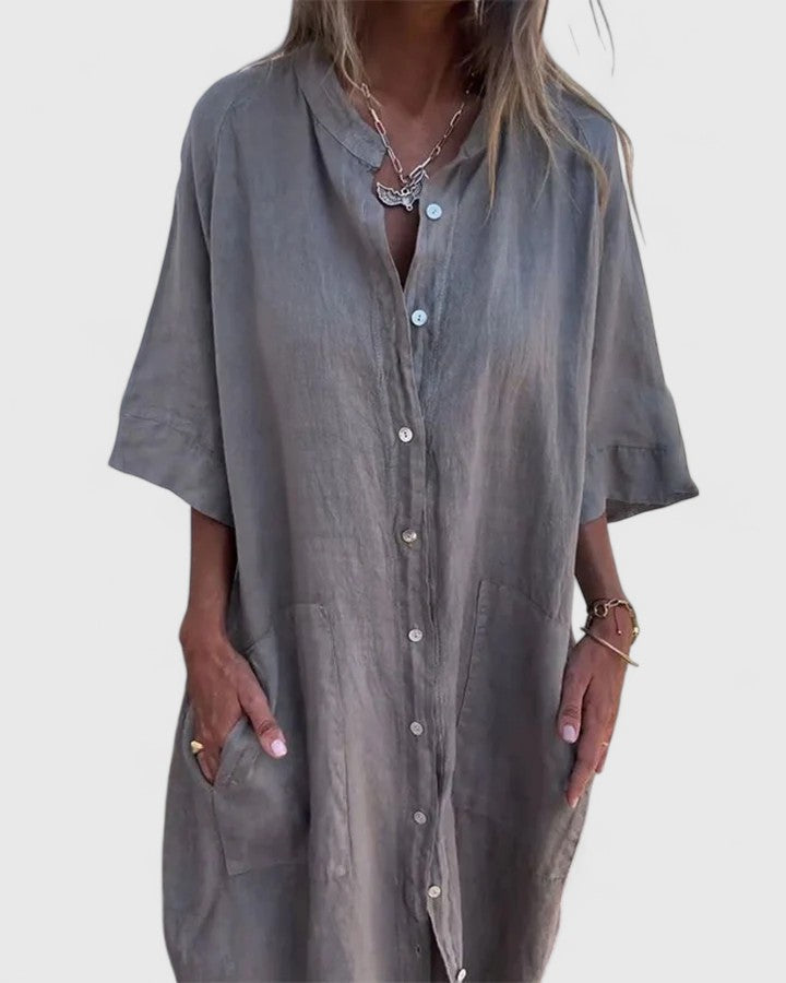 Side profile of the Mila relaxed dress in a deep green, showcasing its elegant drape and flow.