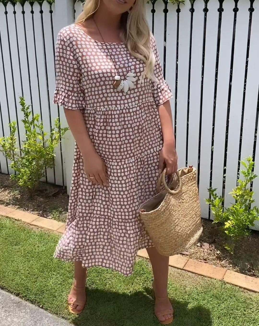 Close-up detail of the rounded neckline and mid-length flared sleeves of the boho midi dress.