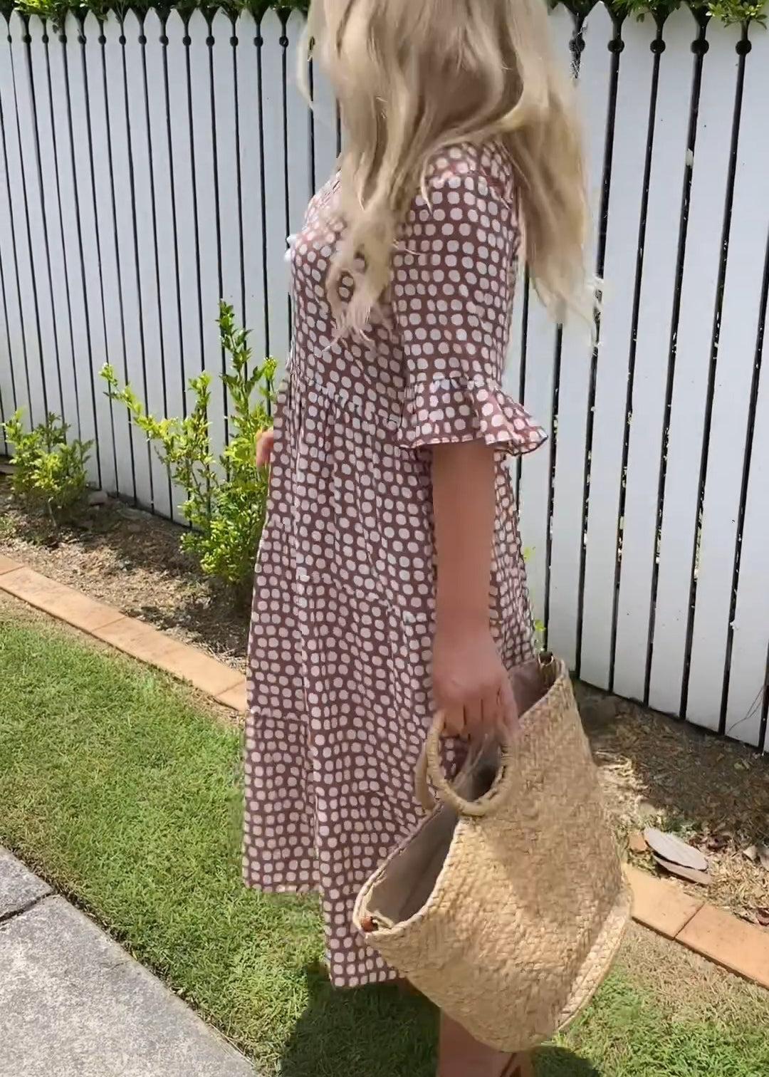 Side profile of the brown boho midi dress, highlighting its flowing silhouette and comfortable drape.