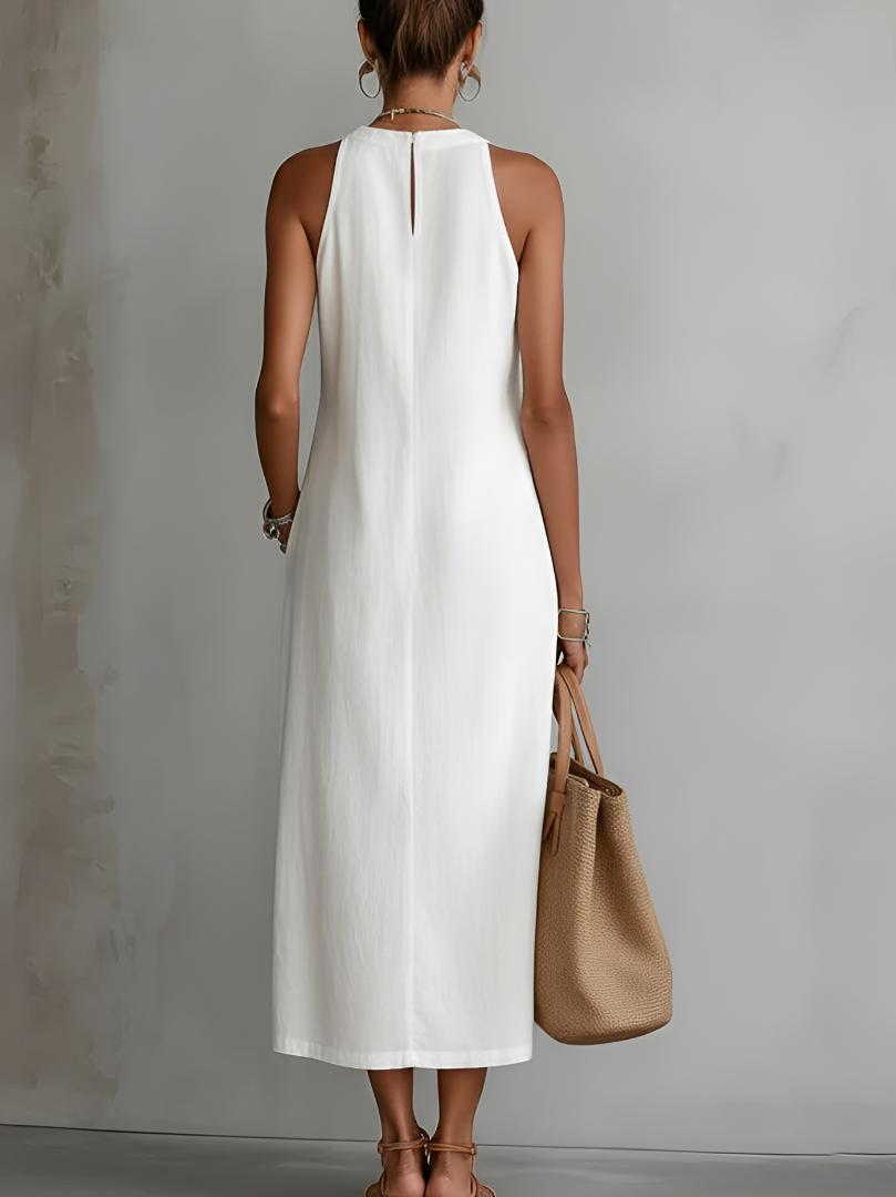 Side profile of a woman in a green Marlowe linen midi dress, highlighting the elegant drape and midi length.