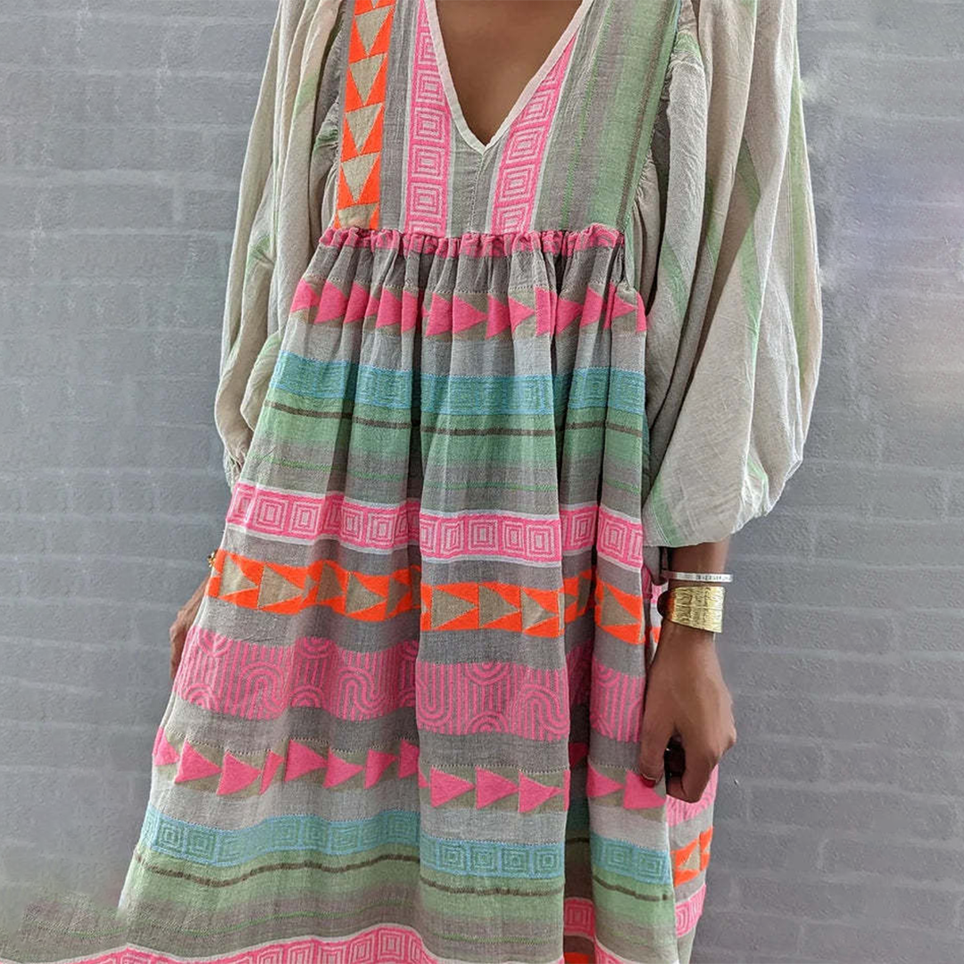 Detail of the empire waist ruching and the soft, lightweight material of the multicolor boho patchwork midi dress.