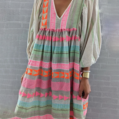 Detail of the empire waist ruching and the soft, lightweight material of the multicolor boho patchwork midi dress.