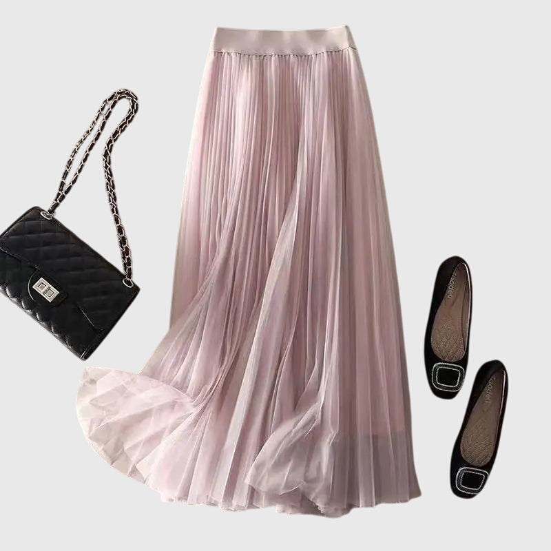Side profile of the Seraphina pleated midi skirt in a soft rose, highlighting the high-waisted fit and graceful movement.