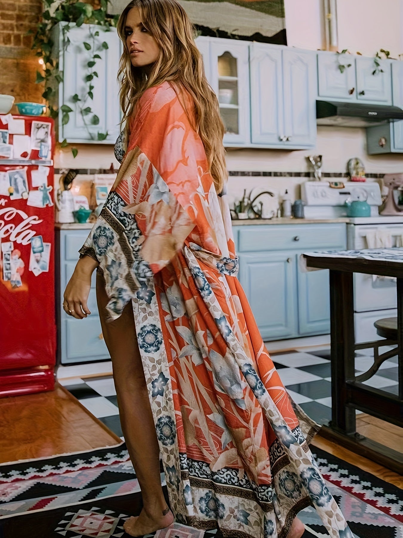 Front view of a woman wearing the Seraphina flowy floral kimono over a swimsuit on a sunny beach.