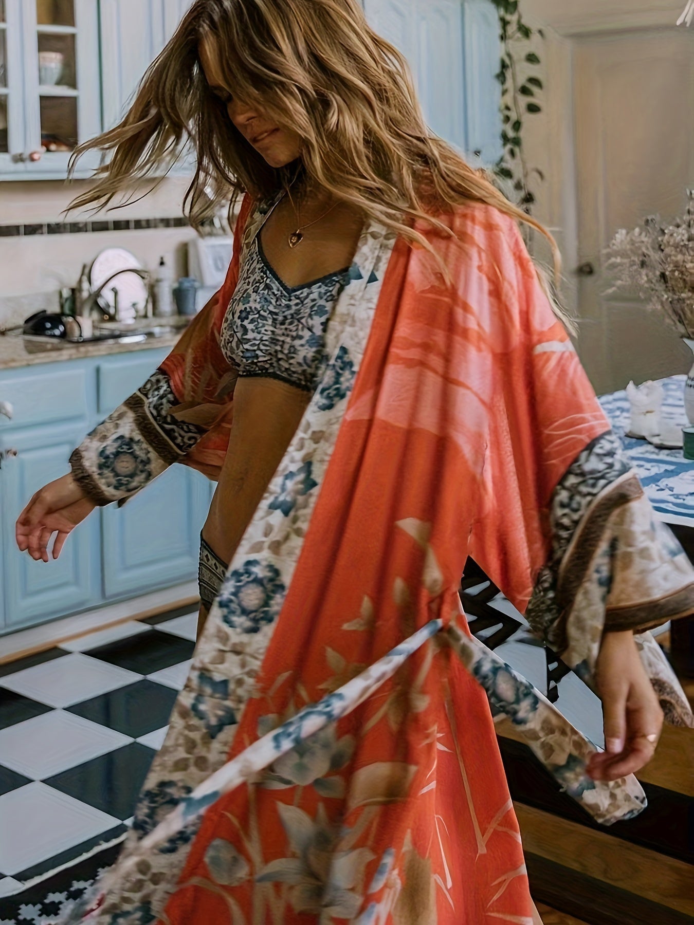 Woman casually walking, with the open front of the flowy floral kimono revealing her summer attire.